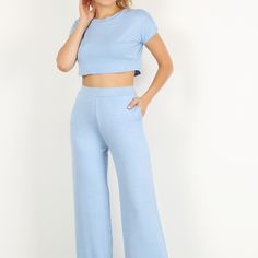 Solid Two Piece Pants Set Featuring A Short Sleeve Crop Top And High Waisted Wide Leg Pants With Pockets. Blue High Waist Sets For Spring, Casual Blue Short Sleeve Pant Set, Casual Blue Sets With Elastic Waistband, Blue Cropped Cotton Pants, Cropped Bottoms With Elastic Waistband For Loungewear, Blue Stretch Cropped Bottoms, Light Blue Wide Leg Bottoms For Loungewear, High Waist Light Blue Pants For Loungewear, Casual High Waist Matching Set