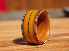 an orange and yellow ring sitting on top of a wooden table