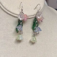 Pastel dangle chain flowers bring in cheerful days ahead.  They are all glass except for the little flower at top as an accent. A dark green glass leaves brings out the color of the flowers.  In side of each flower is a Swarovski crystal. They measure about 1 3/4 inches from below the ear hooks. What a beautiful pair of sunny delightful pastel glass Bell earrings to wear, ~~Anytime    ENJOY Use ear plugs to not loose~! Chain Earrings Dangle, Bell Earrings, Flower Chain, Earrings Pink, Green Flower, Ear Plugs, Ear Hook, Chain Earrings, Pale Green