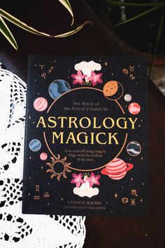 an astrology magick book sitting on top of a doily