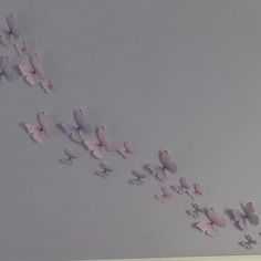 several pink butterflies flying in the air on a gray background with white walls and ceiling