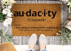 a person standing in front of a door mat with the words auda city on it