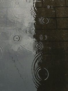 rain drops falling on the ground in front of a puddle with words written in english and arabic