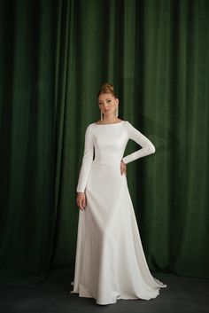 Wedding dress in a modest and minimalistic style! A minimalistic, modest wedding dress with long sleeves would be perfect for autumn and winter wedding crafted of high-quality crepe and decorated with bridal buttons. The boat neckline and high back complement each other, making the dress stylish and modern. This A-line elegant dress is for brides who dream of minimalistic and graceful style. The back of the wedding dress is decorated with bridal buttons that go all the way from the back to the e Bridal Buttons, Elegant Bridal Dress, Graceful Style, Wedding Dress With Long Sleeves, Modest Wedding Dress, Crepe Wedding Dress, Dress Stylish, Wedding Court, Wedding Reception Dress