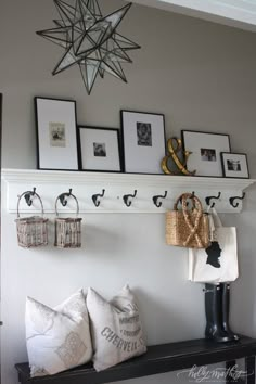 a shelf with some pictures hanging on it and two baskets sitting on top of it