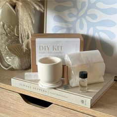 an assortment of items sitting on top of a wooden table next to a vase and book