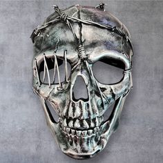 a metal skull mask with barbed wire on it's face and the eyes are closed