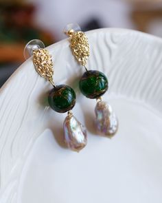 "This gorgeous pair of teardrop shape Baroque Pearl earrings has beautiful purple metallic lustre with hints of green. Very unique colour with own character from mother nature. The pearls and handmade green glass beads dangling under a pair of trendy design ear studs. The pictures do not do this earrings justice Let this unique piece be a perfect accessory for your everyday adventures or a gift to the loved one.  Because each item is handmade there may be differences from the picture viewed. Eac Green Teardrop Beaded Earrings For Party, Unique Green Teardrop Beaded Earrings, Green Beaded Earrings With Dangling Beads For Wedding, Elegant Green Beaded Teardrop Earrings, Green Pearl Drop Jewelry, Handmade Baroque Pearl Earrings For Party, Elegant Green Dangle Beaded Earrings, Green Pearl Charm Drop Earrings, Green Pearl Drop Jewelry With Round Beads