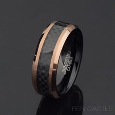 a black and gold wedding ring with carbon fiber inlays on the outside,