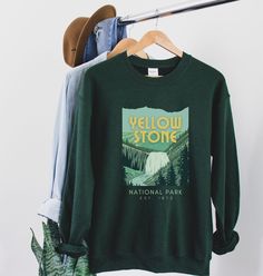 *PLEASE ask any questions about holiday shipping dates prior to purchase:) YELLOWSTONE Sweatshirt featuring Gibbon Falls | Yellowstone Shirt A cozy way to commemorate your Yelllowstone adventure! Printed on a classic unisex Gildan cotton sweatshirt. Colors: Forest Green *50% Cotton 50% Polyester *Medium-heavy fabric * Loose fit *Runs pretty true to size, slightly larger ♥♥SIZING♥♥ ♥Modern Unisex Fit. Women may want to size down if you prefer a more fitted look. Men may want to size up if you wan Green Crew Neck Top For Adventure, Green Crew Neck Top For Camping, Green Tops With Letter Print For Hiking, Green Letter Print Tops For Hiking, Relaxed Fit T-shirt For Fall Outdoor Activities, Relaxed Fit Crew Neck Tops For Hiking, Crew Neck Letter Print Hiking Top, Green Crew Neck Sweatshirt For Outdoor, Casual Hiking Sweatshirt With Letter Print