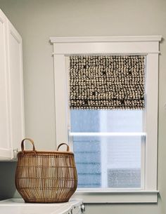 a basket sitting on top of a washer next to a window