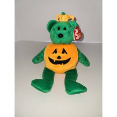 a green teddy bear with a pumpkin on it's chest