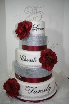 a three tiered wedding cake with red flowers on the top and nameplates