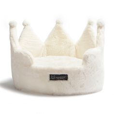 a white dog bed with a black tag on it's front and bottom part