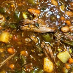 meat and vegetable soup in a pot with spoon