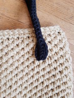 a crocheted bag with a black handle