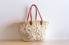 Discover the perfect blend of style and practicality with our Handwoven Straw Bag with Flowers Design. Crafted with precision from natural straw and adorned with a charming floral pattern, this stylish tote is ideal for various occasions, from casual outings to market trips. A beautifully crafted bag to accompany you everywhere. Straw Bag with Flowers Design - Shopping Basket - French Market Basket - Handcrafted Moroccan Basket Whether you're looking for a chic market tote, a charming everyday bag, or a thoughtful gift, this Straw Bag with Flowers Design is a perfect choice! Many of our customers also love using these bags as stylish storage or decorative accents at home. This bag is sturdy, durable, and will maintain its shape for years to come. Your bag might get slightly misshapen durin Casual Embroidered Straw Tote Bag, Embroidered Beige Straw Bag For Daily Use, Beige Embroidered Straw Bag For Everyday Use, Embroidered Straw Bag For Summer, Embroidered Beige Straw Bag For Travel, Bohemian White Straw Shoulder Bag, Spring Vacation Embroidered Bag, Spring Vacation Embroidered Bags, Embroidered Natural Straw Travel Bag