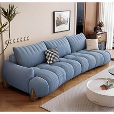 a living room with a blue couch and coffee table on the floor in front of a large window