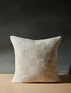 a white pillow sitting on top of a wooden table