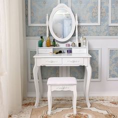 a white dressing table with a mirror and stool