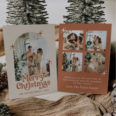 two christmas cards sitting on top of a table