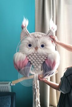 a woman is holding an owl hair comb