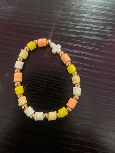 A orange and yellow cross bracelet made with clay beads Yellow Clay Bead Bracelet, Clay Bead Bracelet Ideas, Bead Bracelet Ideas, Clay Bead Bracelet, Clay Bead, Bracelet Ideas, Cross Bracelet, Orange And Yellow, Clay Beads