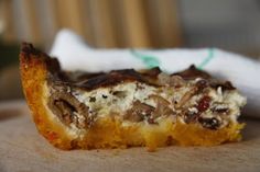 a piece of food sitting on top of a wooden table next to a white towel