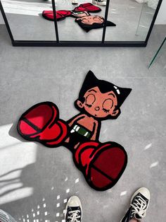 a person standing on the floor in front of a mirror with an image of a cartoon character