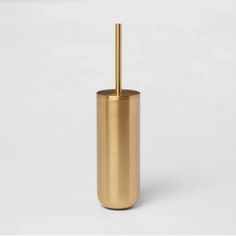 a gold toilet brush holder on a white background