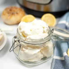 a jar filled with whipped cream next to lemons