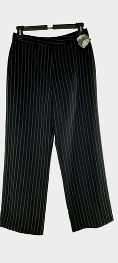 Elevate your wardrobe with these stylish and versatile black pants by Jaclyn Smith. Featuring a classic fit with a straight leg and flat front, these pants are perfect for any occasion, whether it's a formal business meeting or a casual night out. The lapover waist band with hook closure adds a unique touch, while the black with grey and beige pinstripes pattern gives a subtle yet sophisticated look. Light wrinkles.  42 inches around hip area,  7 inch front opening,  leg opening at hem is 22 inches.  All measurements are approximate. Has back pockets. Crafted from a blend of polyester, cotton, and acetate lining, these pants are machine washable for easy care. With a 30 inch inseam and a 30 inch waist size, they are tailored to fit a regular size 14 woman. Ideal for fall, winter, and sprin Striped Wide Leg Formal Pants, Formal Striped Wide Leg Pants, Striped Wide Leg Pants For Formal Occasions, Pinstripe Wide Leg Pants For Formal Occasions, Elegant Striped Office Pants, Elegant Striped Pants For Office, Elegant Fitted Pants With Vertical Stripes, Formal Pinstripe Ankle-length Pants, Elegant Black Pants For Career