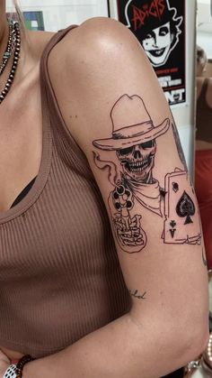 a woman with a tattoo on her arm holding a cell phone and playing cards in front of her