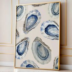 an abstract painting with blue and white designs on the wall next to a gold frame