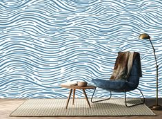 a chair and table in front of a wall with waves painted on it