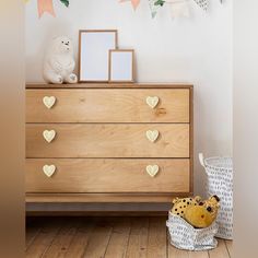 a wooden dresser with two teddy bears on it