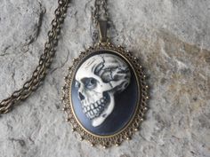 "Skull cameo necklaces, 2\" long (see pic Gorgeous color and amazing detail. I can also customize the color), each cameo is individually hand painted, each an original!! The cameo can also be set in silver These necklaces can be made with almost every cameo in my store, so please feel free to browse, and convo me with a special order The cameos are set in quality bronze settings with matching 24\" adjustable rolo link chain with a lobster claw clasp Please do visit my shop, I make a huge selecti Steampunk Skull Jewelry For Halloween, Steampunk Skull Jewelry Gift, Vintage Skull Necklace For Gift, Vintage Skull Shaped Necklace For Gift, Vintage Nickel Free Necklaces For Halloween, Vintage Nickel-free Necklace For Halloween, Handmade Gothic Skull Necklace, Skull Cameo, Painted Skull