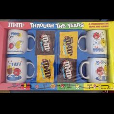 four coffee mugs in a box with the words through the years printed on them