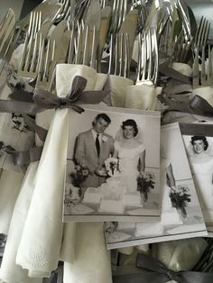 a table topped with lots of silverware next to pictures and napkins on top of each other