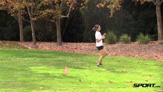 a woman running across a lush green field