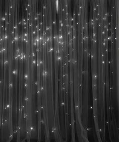 black and white photo of curtains with lights