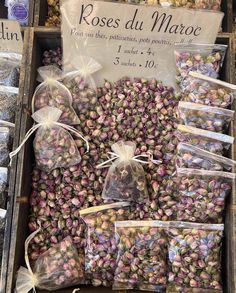 several bags of dried flowers are on display in a box with ribbons and tags around them