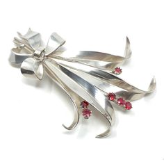 This pretty brooch dates from the 1940s. It's a delightful example of French silver.  Condition Report: Excellent The Details... This brooch is constructed from silver. It features a posy design and is detailed with small, round, claw set, ruby paste stones. The brooch fastens with a trombone clasp and the fastening pin is fitted to the brooch with a round hinge. The brooch measures 7cm x 5cm. It features a French silver makers lozenge shaped stamp - inside which are the initials 'LRS' and what Mid-century Silver Brooch For Collectors, Mid-century Silver Brooches For Collectors, Retro Silver Brooch Pin, Silver Retro Brooch Pin, Silver Retro Brooches For Gift, Vintage Sterling Silver Brooch For Wedding, Vintage Sterling Silver Brooches For Wedding, Retro Silver Brooches For Anniversary, Silver Retro Brooches For Anniversary