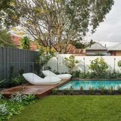 a backyard with a swimming pool and wooden decking