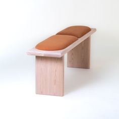 a wooden bench with two cushions sitting on it's sides in front of a white background