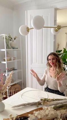 a woman standing in front of a white table