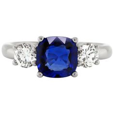 This beautiful engagement ring features a cushion shaped royal blue sapphire weighing a total of 2.19 carats mounted in a four claw, open back setting. The sapphire is accompanied by two round brilliant cut diamonds, one on either side, with a total combined weight of 0.75 carats also in open back, four claw settings, all mounted in platinum. Hallmarked 950, stamped PT950. UK finger size 'O'. Beautiful Engagement Ring, Platinum Engagement Ring, Sapphire And Diamond Ring, Platinum Engagement Rings, Beautiful Engagement Rings, Shiny Things, Three Stone Rings, Sapphire Diamond, Round Brilliant Cut Diamond