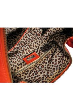 Keep it fierce wherever you go with this fun handbag from Dole & Gabbana! A colorful design is given a safari chic twist with reptile embossed trim and a leopard print lining. Perfect for any boho babe who loves their animal prints. Will pair great with maxi dresses and gold jewelry. Textured leather Gold-toned hardware Top carrying handle with reptile embossed trim Top zipper closure Leopard print lining One interior zippered pocket Two interior open pockets Very light staining on right side an Orange Leather Shoulder Bag With Zipper Closure, Trendy Orange Leather Satchel, Trendy Travel Shoulder Bag With Leather Lining, Leather Orange Satchel For On-the-go, Safari Chic, Trim Top, Animal Prints, Colorful Design, Reptiles