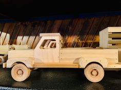 a wooden toy truck sitting on top of a black table next to wood planks