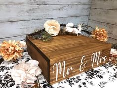 a wooden box sitting on top of a bed covered in flowers